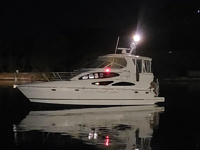 Slide: The Image of 2005 Cruisers Yachts 405 Express Motoryacht illuminated at night on calm water. - 21