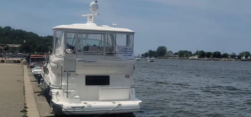 Slide: The Image of 2005 Cruisers Yachts 405 Express Motoryacht docked by a calm waterfront. - 3