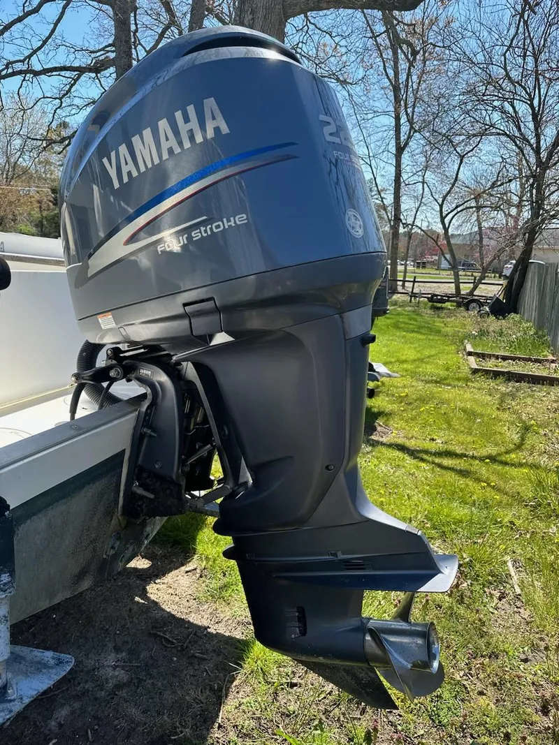 Slide: The Image of Yamaha four-stroke outboard motor on 1985 Mako 224 CC boat, parked on grass. - 2