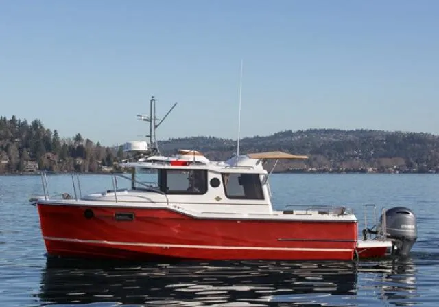 Slide: The Image of 2020 Ranger Tugs 25 boat on a calm lake with scenic background. - 1