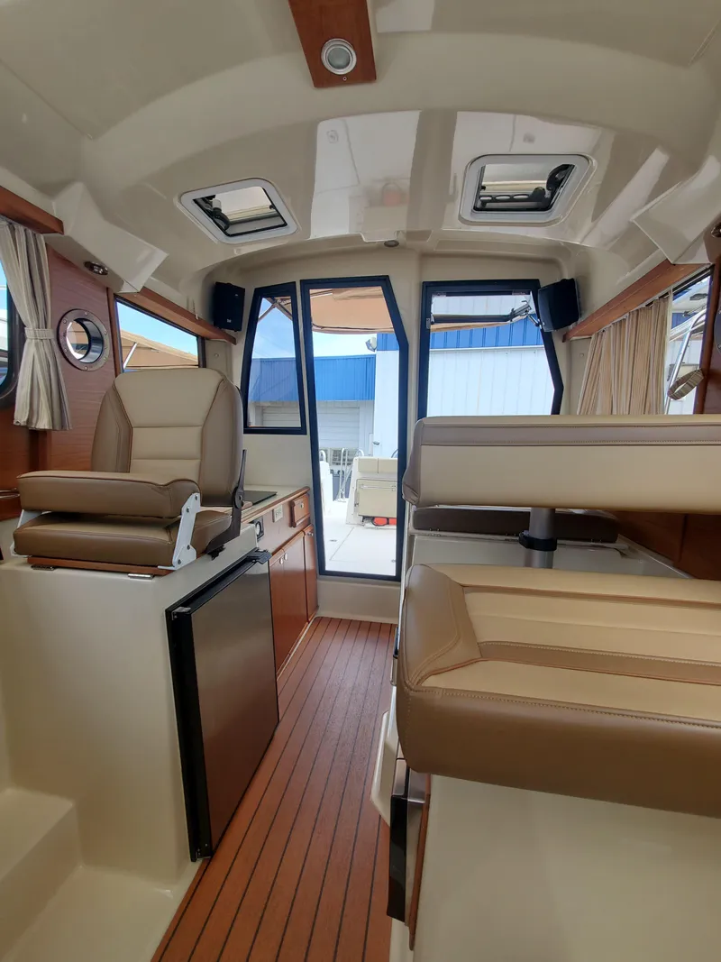 Slide: The Image of Interior of 2020 Ranger Tugs 25 boat with modern seating and wood flooring. - 2