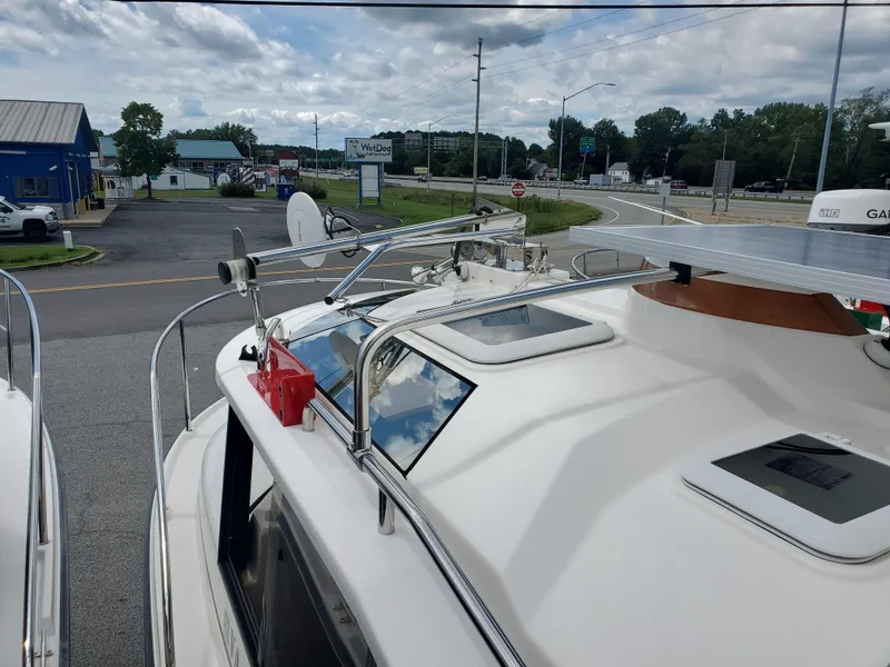 Slide: The Image of 2020 Ranger Tugs 25 boat roof with hatches and equipment, parked near a road. - 25