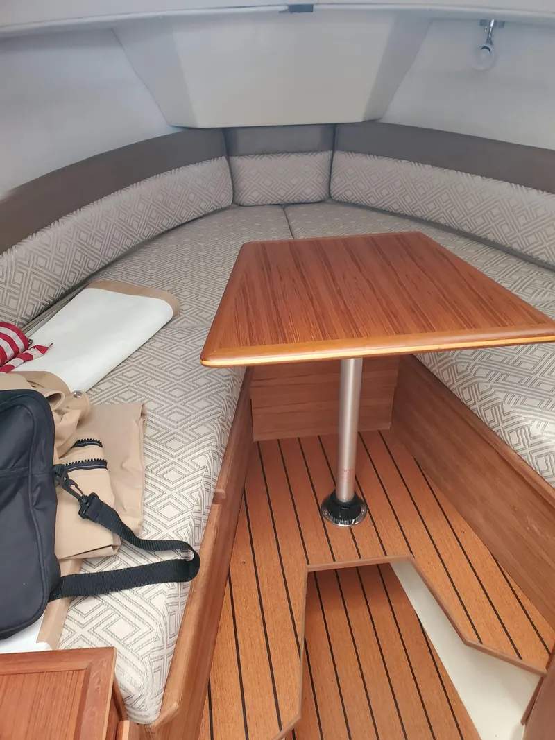 Slide: The Image of 2020 Ranger Tugs 25 interior with wood table and cushioned seating. - 6