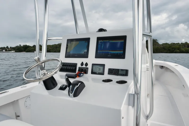 Slide: The Image of 2024 Rambo 27 boat dashboard with dual screens and steering wheel on water. - 1