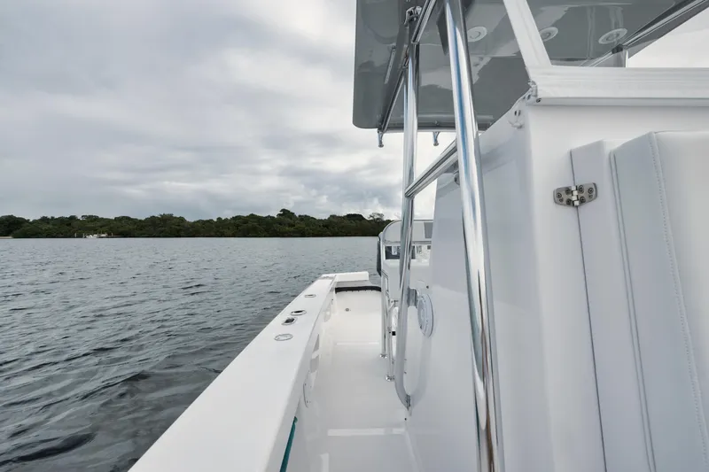 Slide: The Image of 2024 Rambo 27 boat on calm water under cloudy sky. - 11