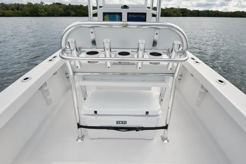 Slide: The Image of 2024 Rambo 27 boat deck with rod holders and Yeti cooler on a calm lake. - 17