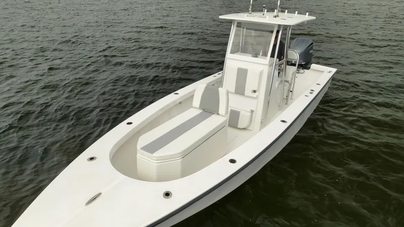 Slide: The Image of 2024 Rambo 27 boat on water, sleek design, white and gray seating. - 22