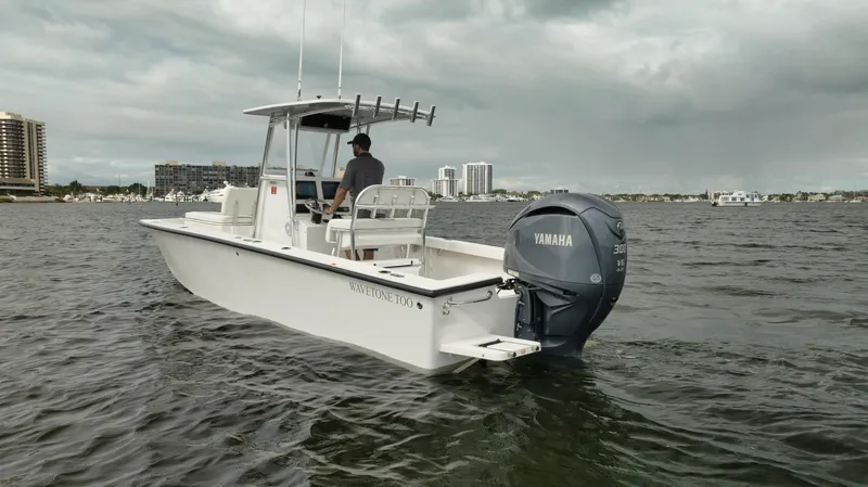 Slide: The Image of Rambo 27 boat (2024) with Yamaha engine on water, cloudy sky background. - 23