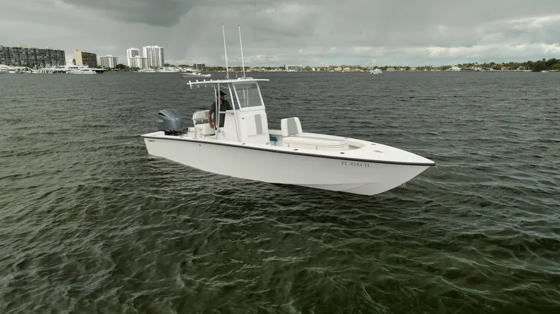 Slide: The Image of Rambo 27 boat, 2024 model, on a calm waterway with cityscape in the background. - 26