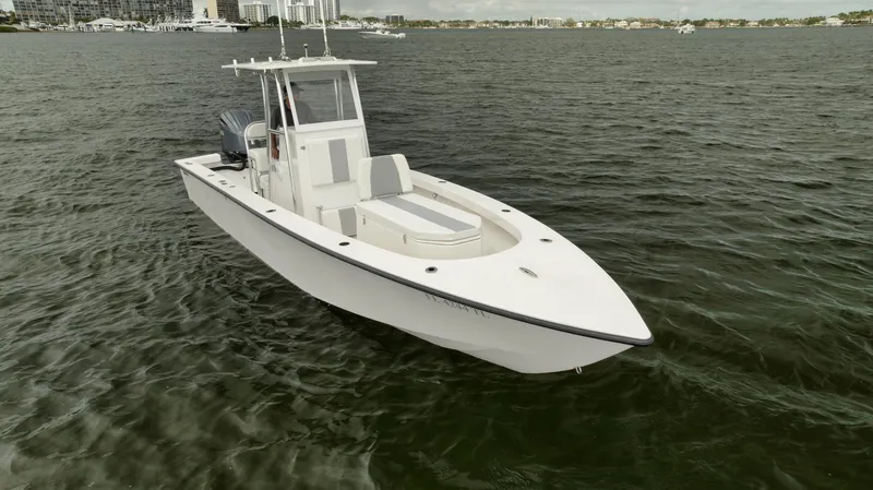 Slide: The Image of 2024 Rambo 27 boat on calm water, sleek white design. - 27