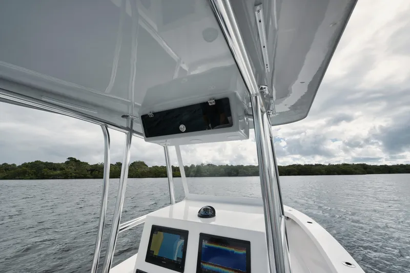 Slide: The Image of 2024 Rambo 27 boat interior with navigation screens on a calm lake. - 3
