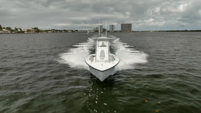 Slide: The Image of 2024 Rambo 27 boat cruising on a lake under cloudy skies. - 30