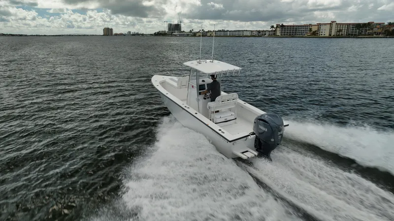 Slide: The Image of 2024 Rambo 27 boat cruising on a scenic waterway under cloudy skies. - 32