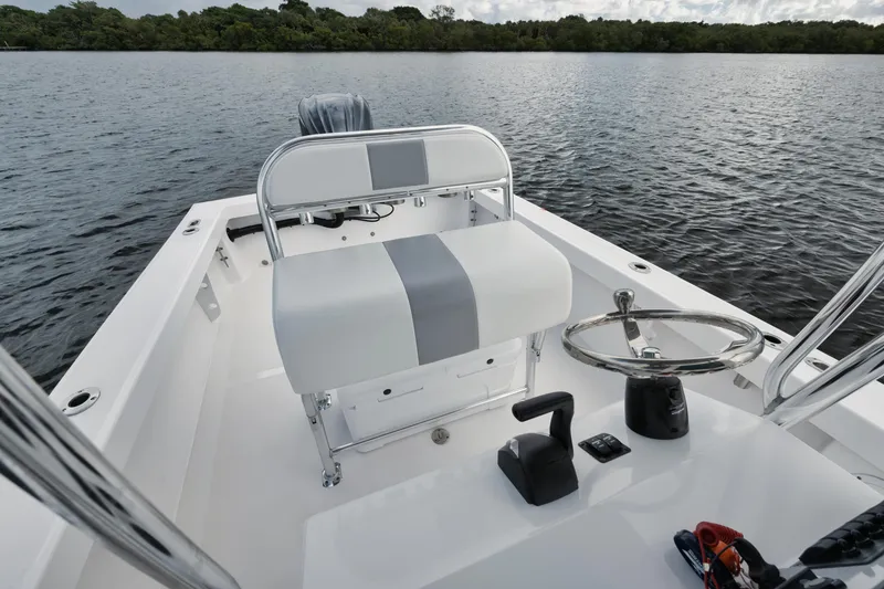 Slide: The Image of 2024 Rambo 27 boat interior with steering wheel and seating on calm water. - 4