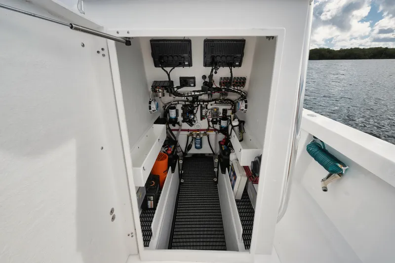 Slide: The Image of Engine compartment of 2024 Rambo 27 boat, showcasing wiring and components by the water. - 9