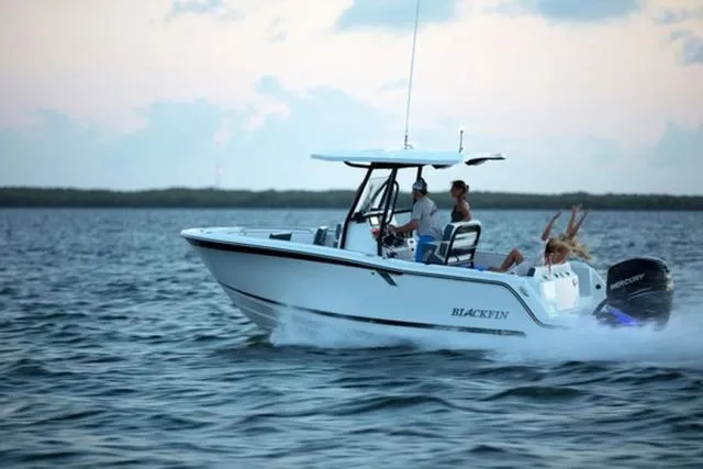 Slide: The Image of 2024 Blackfin 222CC boat cruising on open water with passengers enjoying the ride. - 3