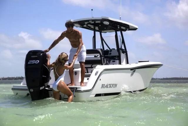 Slide: The Image of 2024 Blackfin 222CC boat in shallow water with two people enjoying the sun. - 4