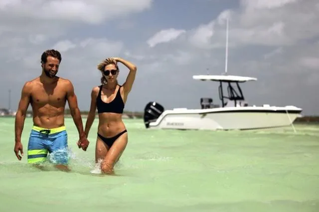 Slide: The Image of Couple walking in shallow water near 2024 Blackfin 222CC boat. - 5