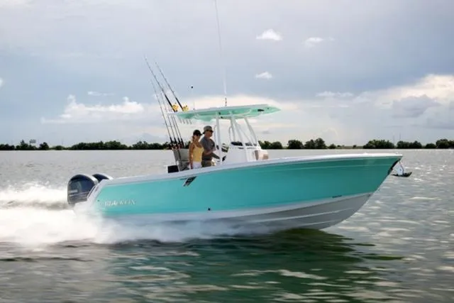 Slide: The Image of 2024 Blackfin 252CC boat cruising on open water, featuring fishing rods and a sleek design. - 1