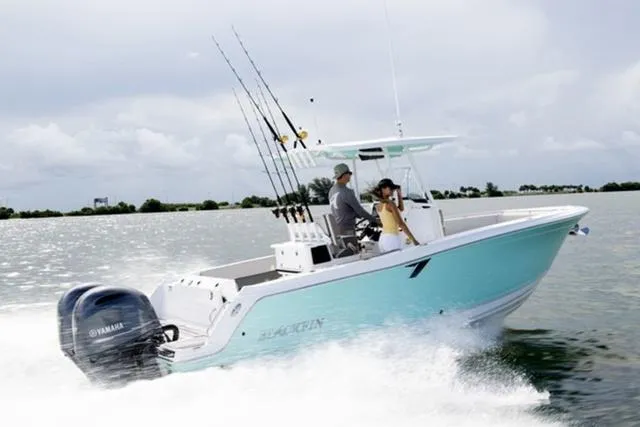 Slide: The Image of 2024 Blackfin 252CC boat cruising on water with fishing rods and Yamaha engine. - 2