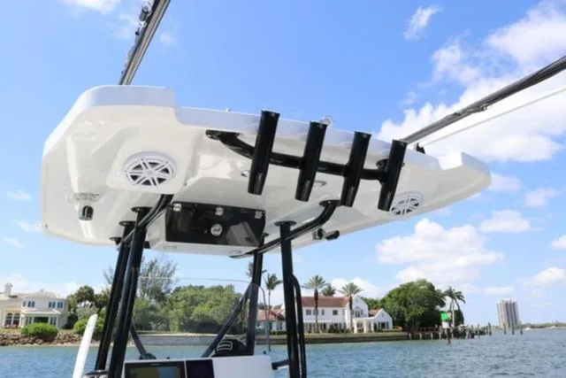 Slide: The Image of 2024 Blackfin 252CC boat with T-top and rod holders on a sunny day. - 8