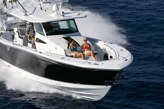 Slide: The Image of 2024 Blackfin 400CC boat cruising on open water with passengers relaxing. - 3