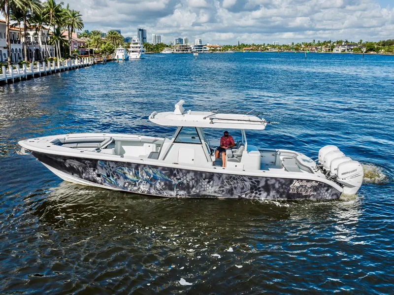 Slide: The Image of 2021 Yellowfin 39 boat cruising on a scenic waterway with palm trees and city skyline. - 13