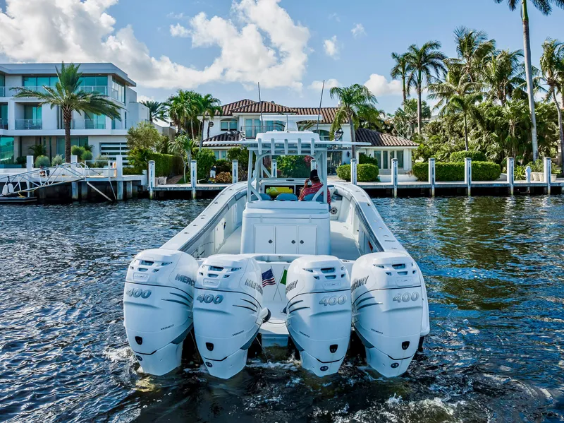 Slide: The Image of 2021 Yellowfin 39 boat with four engines, docked near luxury waterfront homes. - 15