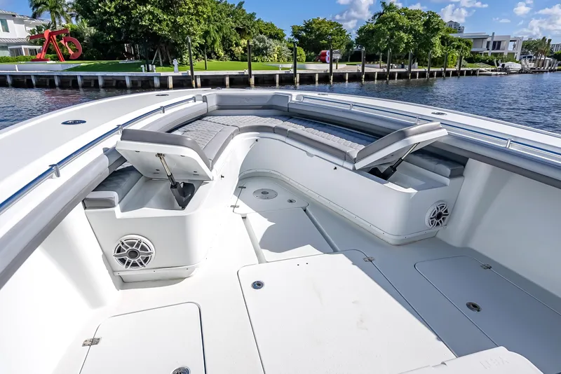 Slide: The Image of 2021 Yellowfin 39 boat interior with seating and storage, docked by a waterfront. - 33