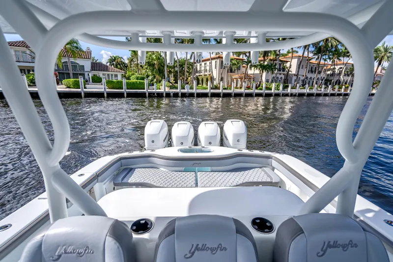 Slide: The Image of 2021 Yellowfin 39 boat with four engines, docked near waterfront homes. - 39