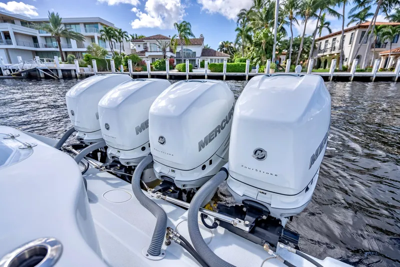 Slide: The Image of 2021 Yellowfin 39 boat with four Mercury outboard engines, docked near luxury waterfront homes. - 46