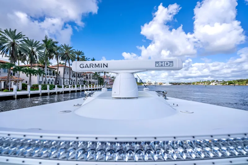 Slide: The Image of 2021 Yellowfin 39 boat with Garmin radar, cruising near waterfront homes under blue skies. - 48