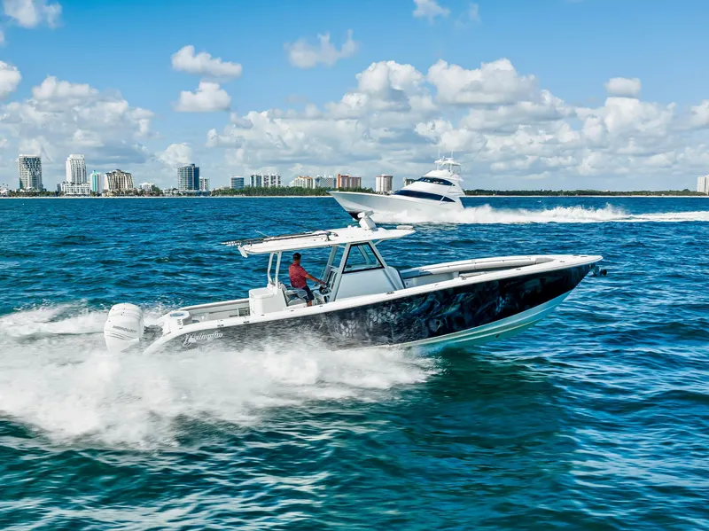 Slide: The Image of 2021 Yellowfin 39 boat cruising on blue ocean with city skyline in background. - 9