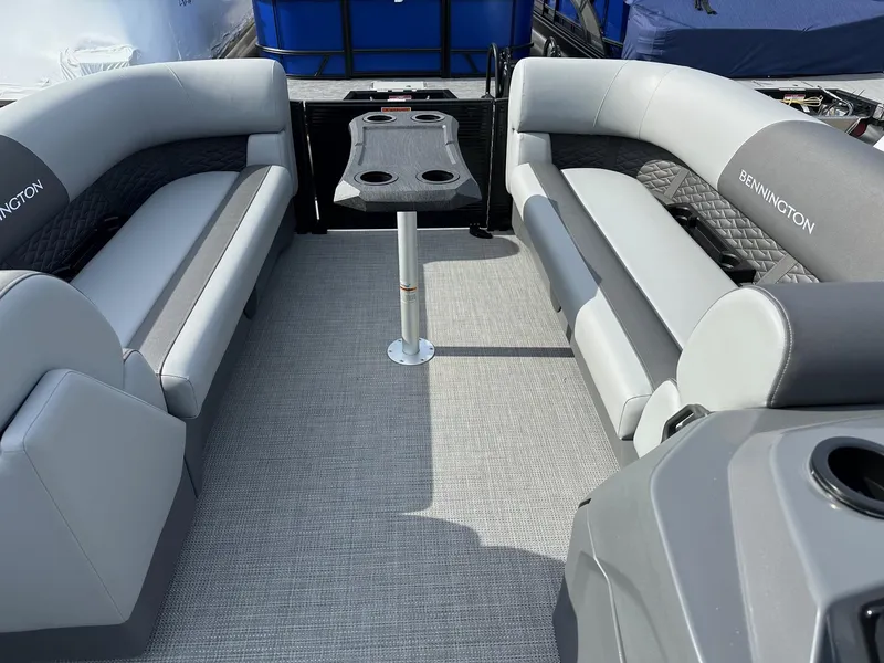 Slide: The Image of 2024 Bennington 20 SSR Quad Bench interior with gray seating and table. - 18