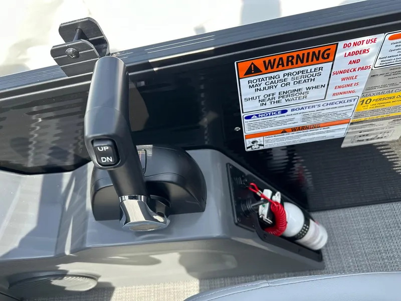 Slide: The Image of 2024 Bennington 20 SSR Quad Bench boat control panel with warning labels and fire extinguisher. - 23