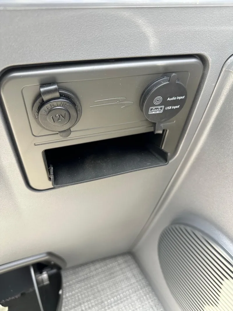 Slide: The Image of 2024 Bennington 20 SSR Quad Bench audio and USB input panel with 12V outlet. - 24