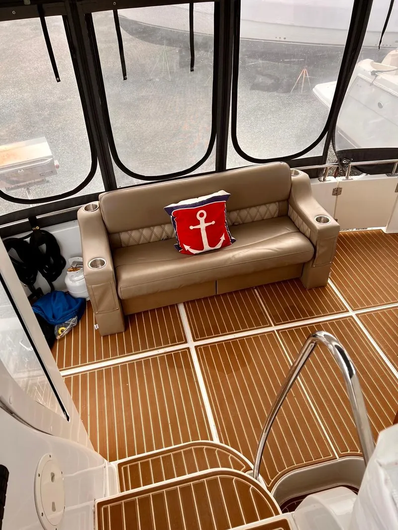 Slide: The Image of 2000 Carver 396 Motor Yacht interior with leather sofa and anchor-themed pillow. - 11