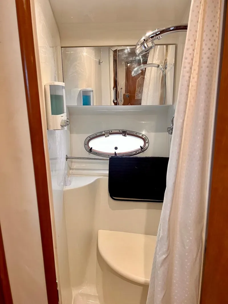Slide: The Image of 2000 Carver 396 Motor Yacht bathroom with shower and porthole window. - 24