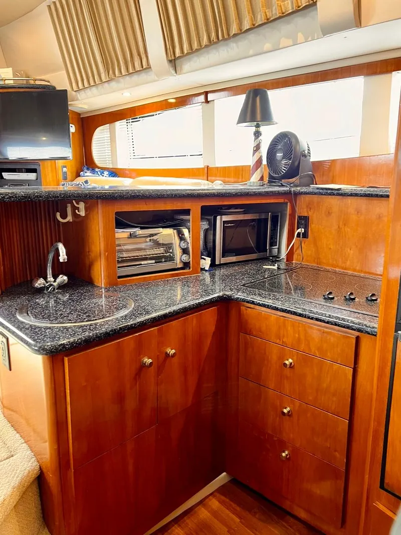 Slide: The Image of 2000 Carver 396 Motor Yacht kitchen with granite countertops and modern appliances. - 25