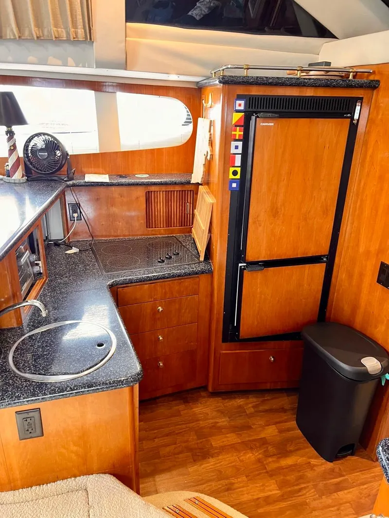 Slide: The Image of Interior kitchen area of a 2000 Carver 396 Motor Yacht with wooden cabinetry and modern appliances. - 26