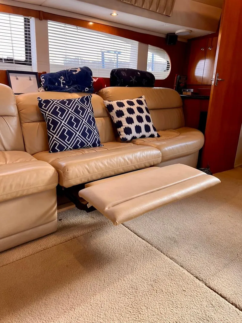 Slide: The Image of Interior of 2000 Carver 396 Motor Yacht with beige leather seating and blue patterned pillows. - 27