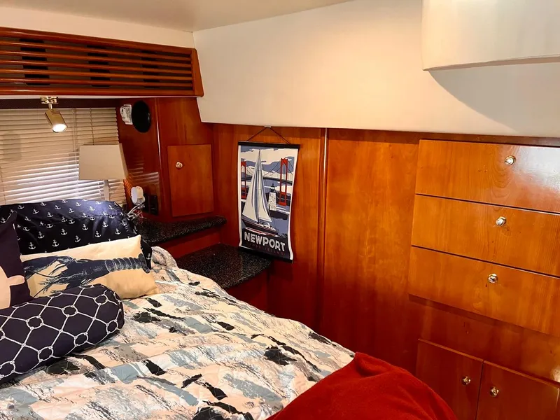 Slide: The Image of Interior of 2000 Carver 396 Motor Yacht bedroom with wooden cabinets and nautical-themed bedding. - 29