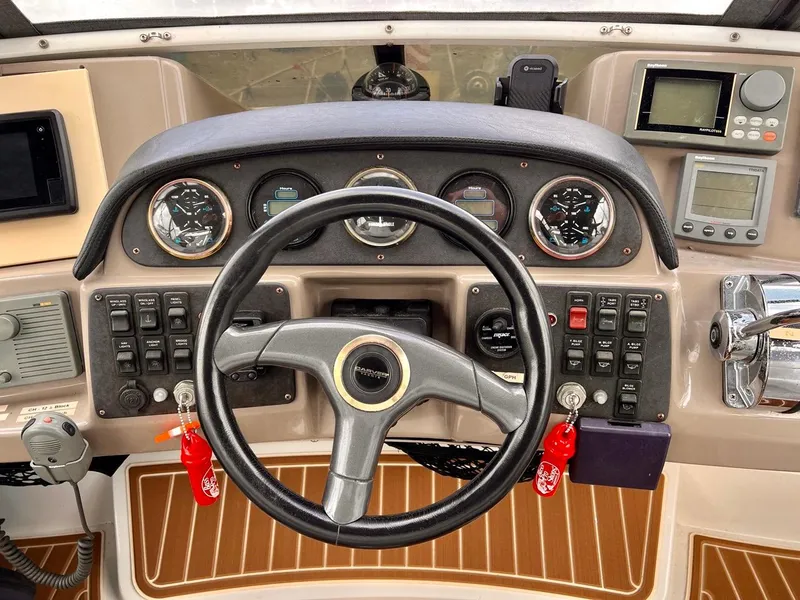 Slide: The Image of Carver 396 Motor Yacht 2000 helm with steering wheel, gauges, and navigation controls. - 8