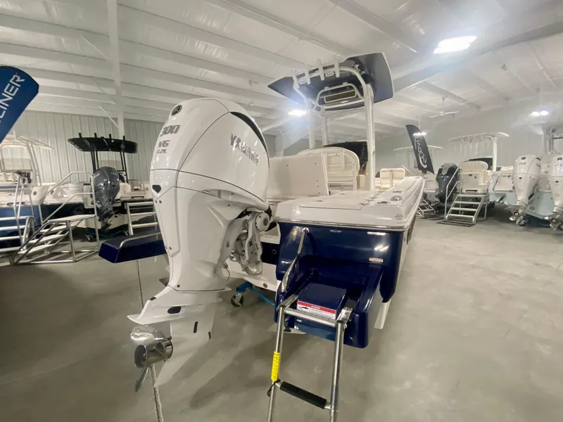 Slide: The Image of 2026 Robalo 246 Cayman boat in showroom, featuring powerful outboard motor. - 1