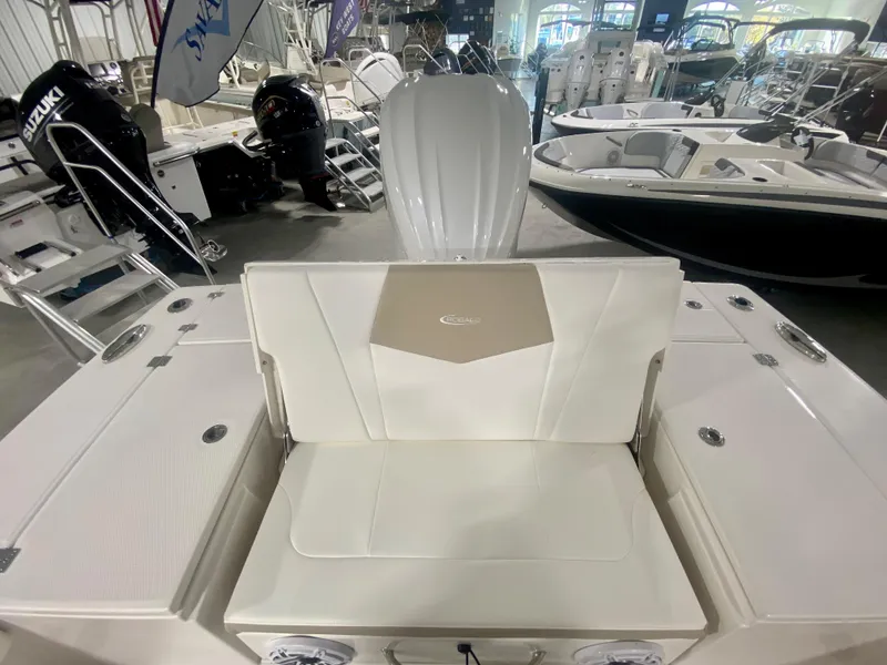 Slide: The Image of 2026 Robalo 246 Cayman boat interior with white seating in a showroom. - 11
