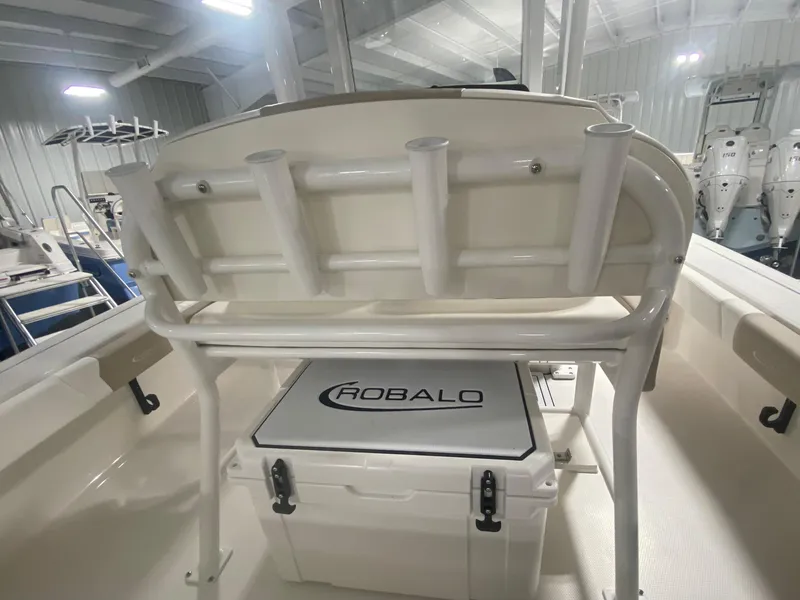 Slide: The Image of 2026 Robalo 246 Cayman boat interior with rod holders and branded cooler. - 13