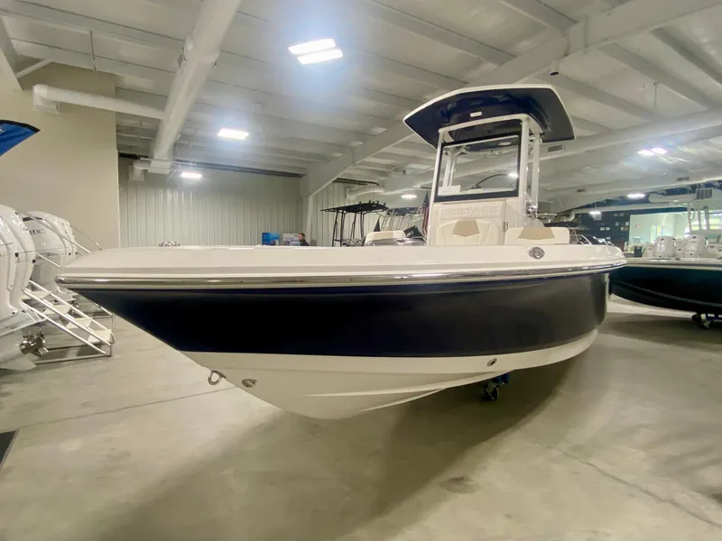 Slide: The Image of 2026 Robalo 246 Cayman boat displayed in a showroom, featuring sleek design and modern amenities. - 2