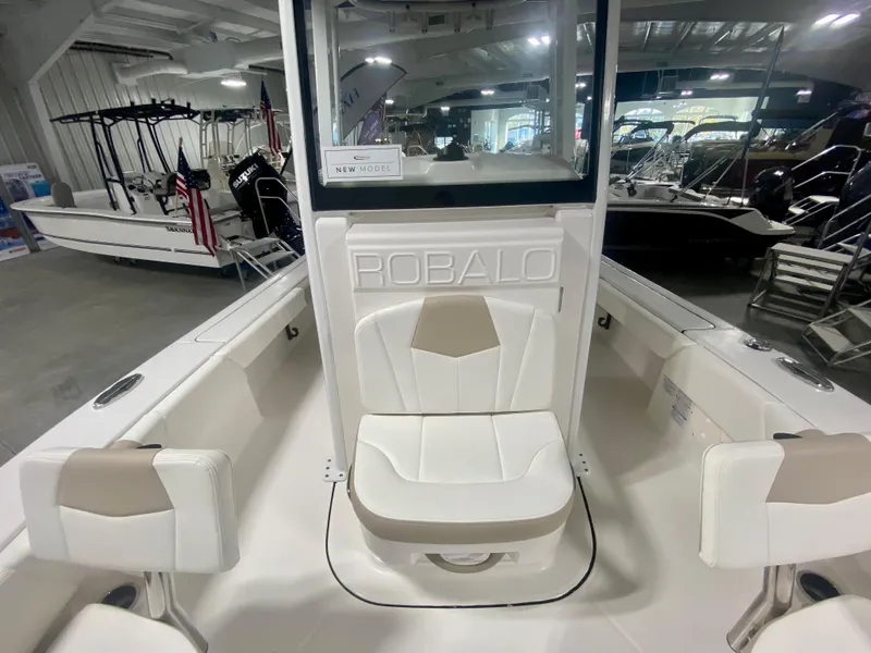 Slide: The Image of 2026 Robalo 246 Cayman boat interior with white seating in a showroom. - 22