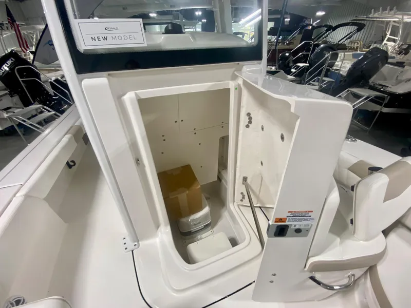 Slide: The Image of 2026 Robalo 246 Cayman boat interior storage compartment with open door. - 23