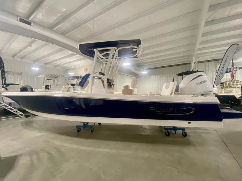 Slide: The Image of 2026 Robalo 246 Cayman boat in showroom, featuring sleek design and Yamaha engine. - 4